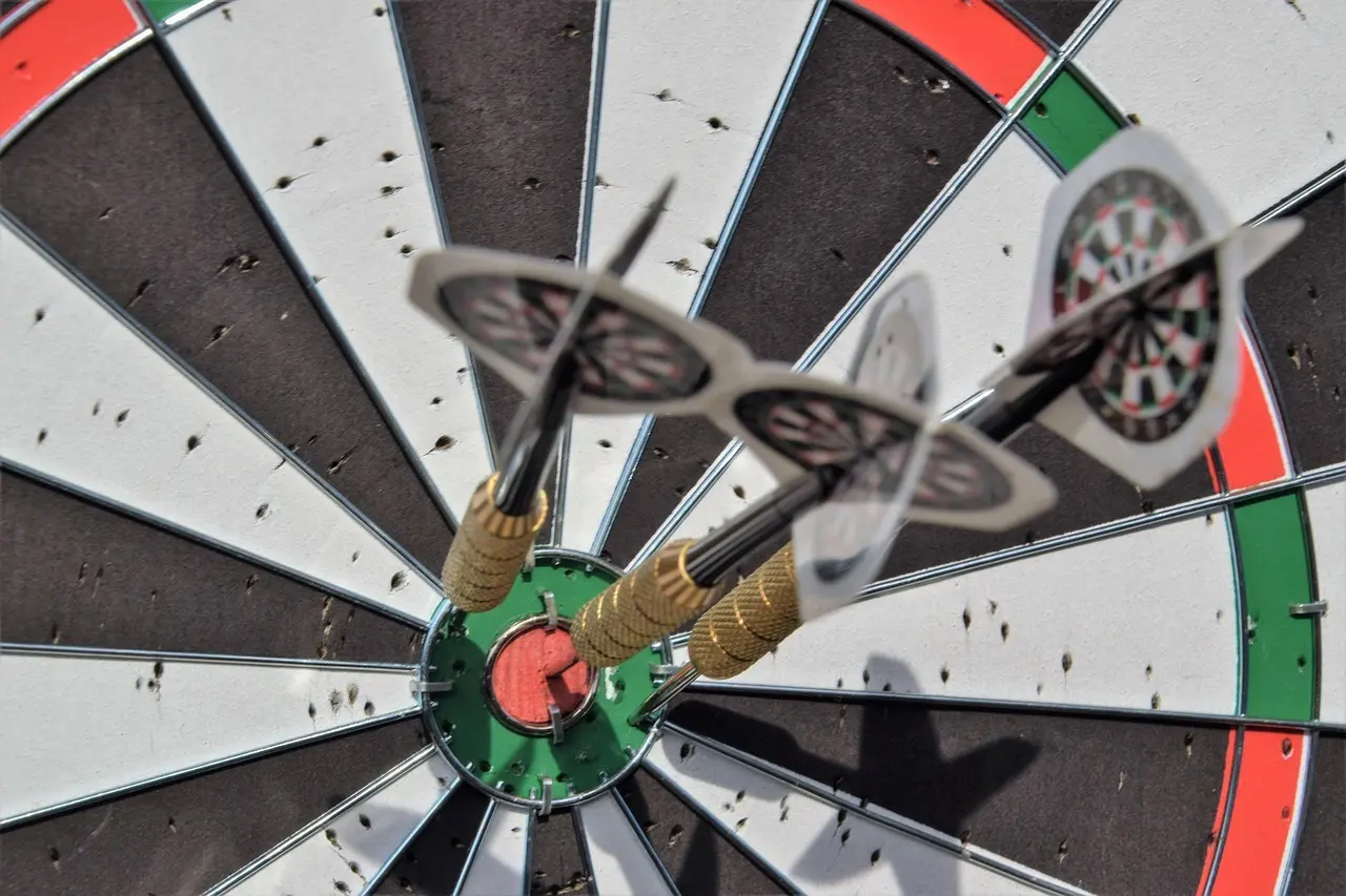 Dartskive med tre pile i bullseye